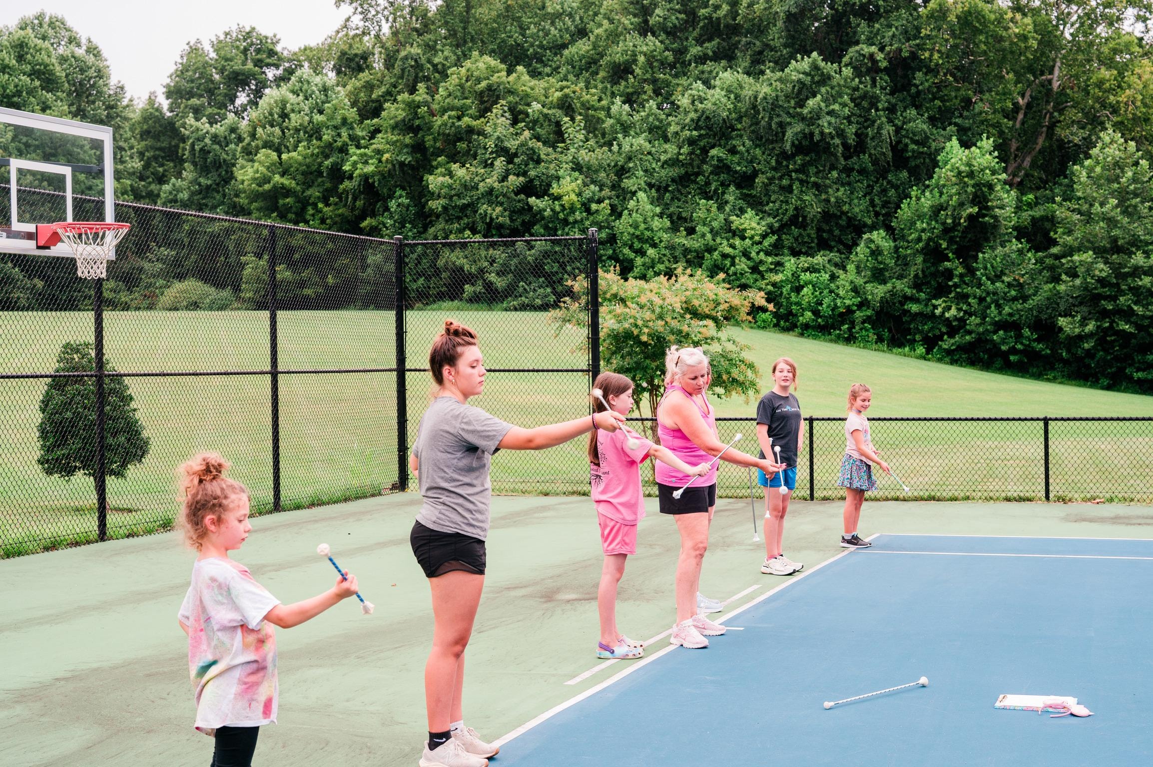 Full class baton twirling practice on court